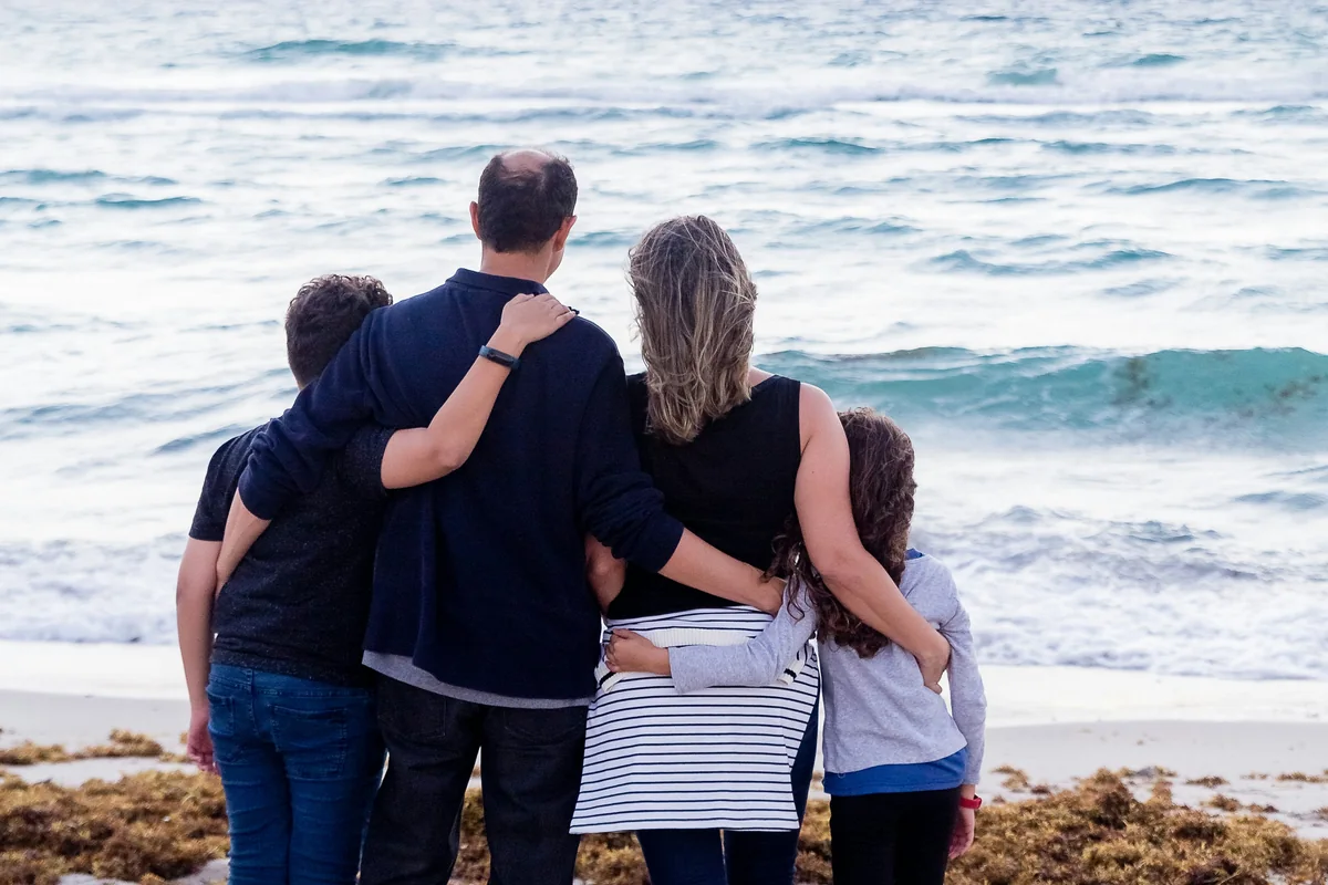 Family standing together at the shore, representing support during a CalAIM assisted living transition