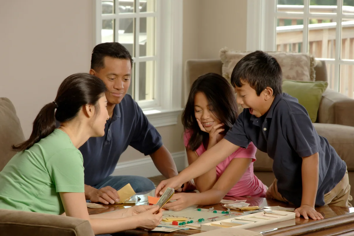Family gathered around a board game at home, representing collaborative transition planning