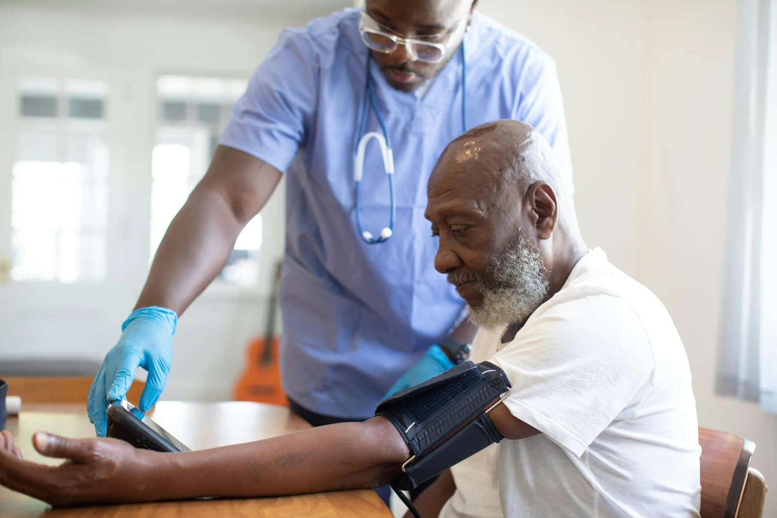 A clinician checking an older adult’s blood pressure