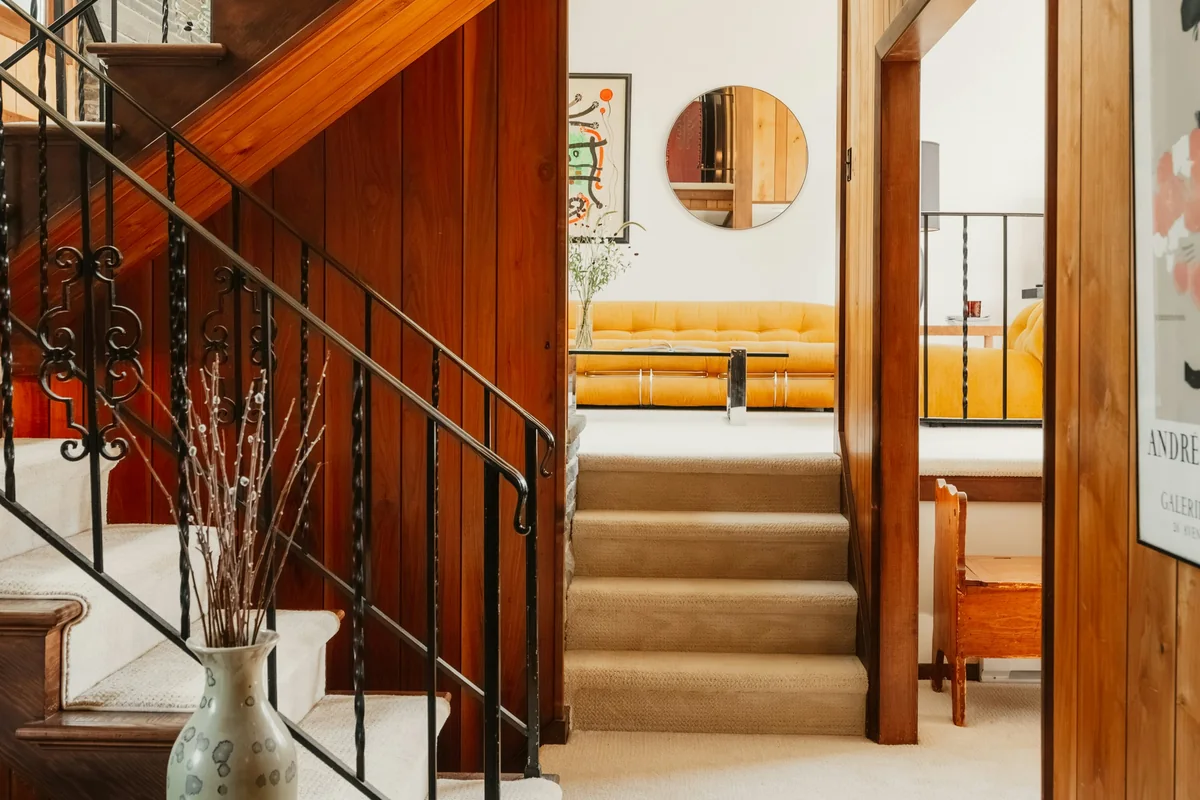A warm residential interior with stairs, railings and multiple levels