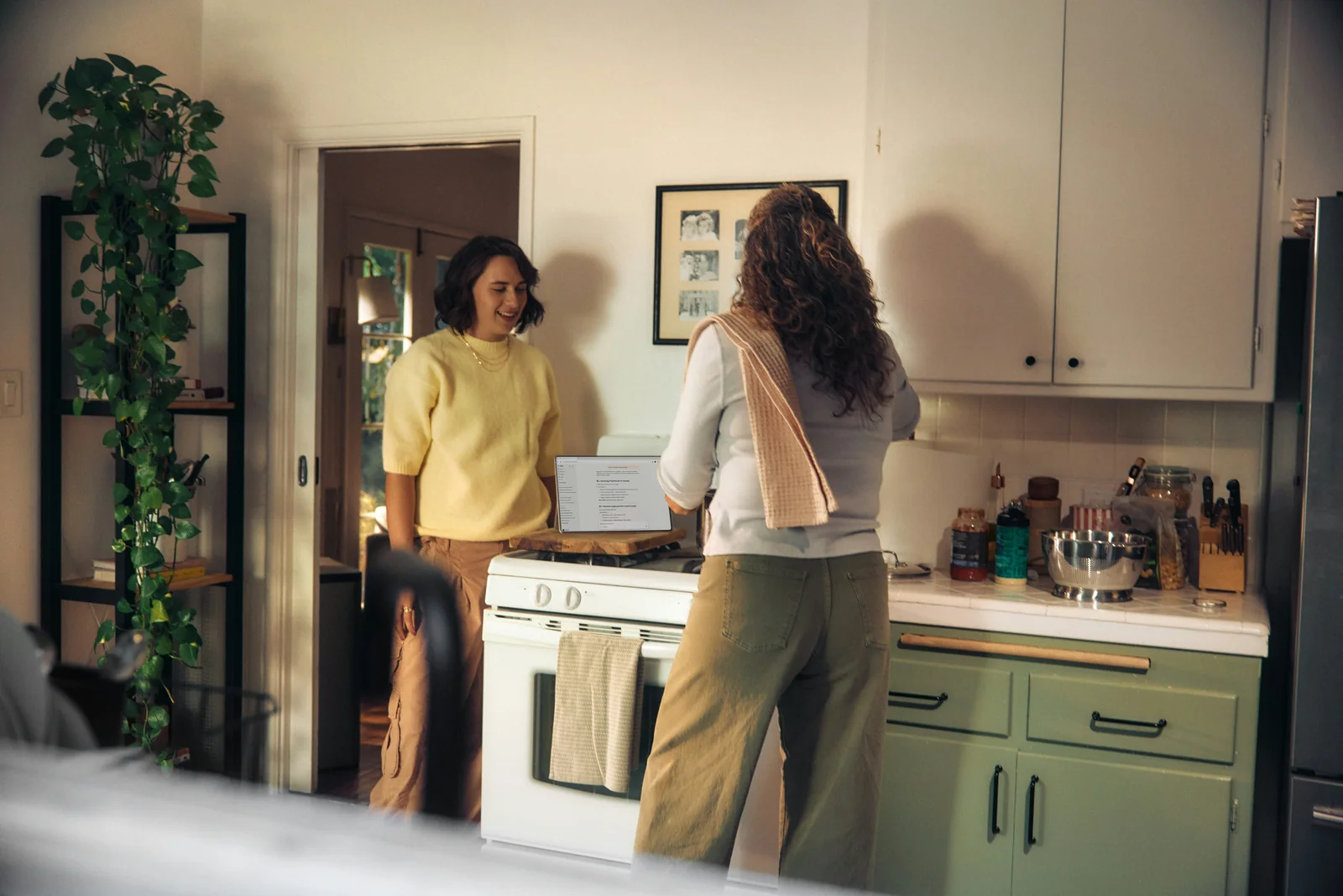 Two women talking together in a warm home kitchen